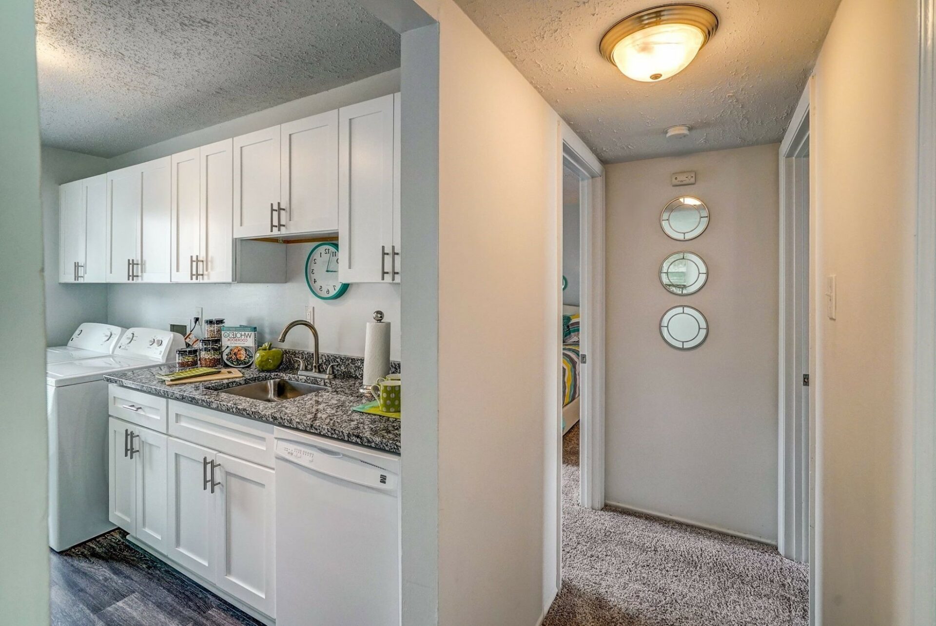 Picture of a hallway leading from a kitchen with white cabinets